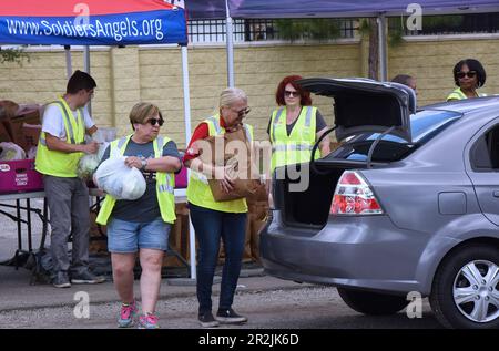 Orlando, Usa. 19. Mai 2023. Freiwillige platzieren Nahrungsmittel in Fahrzeugen bei einer von Lockheed Martin und der nationalen gemeinnützigen Soldiersí Angels in der Lake Baldwin VA Clinic in Orlando gesponserten Militär- und Veteranenveranstaltung für Bedürftige. In Anerkennung des militärischen Aufwertungsmonats erhielten 200 vorab registrierte Veteranen aus der Gegend von Orlando, aktive Militärangehörige, Wachleute und Reservisten durchschnittlich 75 kg frisches Obst und Gemüse, Fleisch und nicht verderbliche Waren auf der Veranstaltung. Kredit: SOPA Images Limited/Alamy Live News Stockfoto