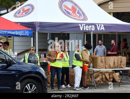 Orlando, Usa. 19. Mai 2023. Freiwillige platzieren Nahrungsmittel in Fahrzeugen bei einer von Lockheed Martin und der nationalen gemeinnützigen Soldiersí Angels in der Lake Baldwin VA Clinic in Orlando gesponserten Militär- und Veteranenveranstaltung für Bedürftige. In Anerkennung des militärischen Aufwertungsmonats erhielten 200 vorab registrierte Veteranen aus der Gegend von Orlando, aktive Militärangehörige, Wachleute und Reservisten durchschnittlich 75 kg frisches Obst und Gemüse, Fleisch und nicht verderbliche Waren auf der Veranstaltung. Kredit: SOPA Images Limited/Alamy Live News Stockfoto