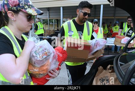 Orlando, Usa. 19. Mai 2023. Freiwillige platzieren Nahrungsmittel in Fahrzeugen bei einer von Lockheed Martin und der nationalen gemeinnützigen Soldiersí Angels in der Lake Baldwin VA Clinic in Orlando gesponserten Militär- und Veteranenveranstaltung für Bedürftige. In Anerkennung des militärischen Aufwertungsmonats erhielten 200 vorab registrierte Veteranen aus der Gegend von Orlando, aktive Militärangehörige, Wachleute und Reservisten durchschnittlich 75 kg frisches Obst und Gemüse, Fleisch und nicht verderbliche Waren auf der Veranstaltung. Kredit: SOPA Images Limited/Alamy Live News Stockfoto