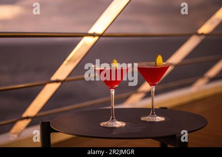 Details von zwei Cocktailgläsern an Deck an Bord des Expeditionsschiffes World Voyager (Nicko Cruises) bei Sonnenuntergang, in der Nähe von Puerto Jiménez, Puntarenas, Stockfoto