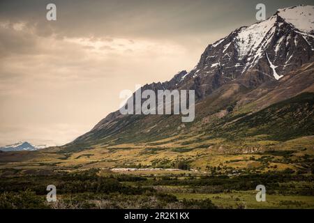 Siedlung am Rande eines mächtigen Bergmassivs, Nationalpark Torres del Paine, Patagonien, Provinz Última Esperanza, Chile, Südamerika Stockfoto