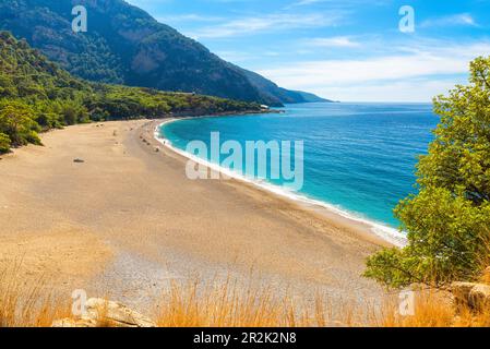 Wunderschöner Kidrak-Strand mit Sandstrand und blauem Wasser in der Nähe der Stadt Oludeniz an der Küste der Mugla-Region in der Türkei. Reiseziel Stockfoto