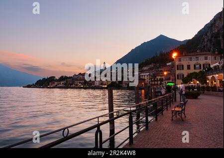 Touristen am langen Gardasee in Limone sul Garda bewundern den Sonnenuntergang. Brescia, Lombardei. Italien Stockfoto
