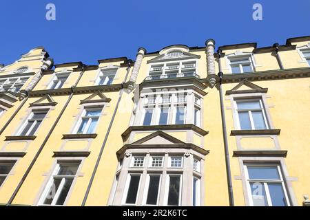 Wunderschöne gelb verzierte Fassade mit Erkerfenster in einem 1900 erbauten Wohngebäude. Stockfoto