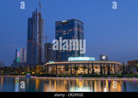 TASCHKENT, USBEKISTAN - 16. SEPTEMBER 2022: Mehrstöckiges Gebäude des Hilton Hotels im Stadtbild in der Abenddämmerung Stockfoto