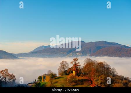 Bergblick über den Luganer See mit Wolkenlandschaft und Sonnenlicht und klarem Himmel in Lugano, Tessin in der Schweiz. Stockfoto