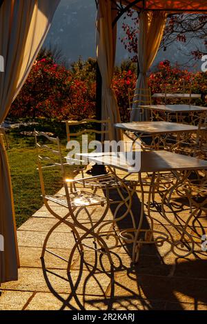 Leeres Restaurant mit Stühlen und Tisch im Freien mit Sonnenlicht im Herbst in Lugano, Tessin in der Schweiz. Stockfoto