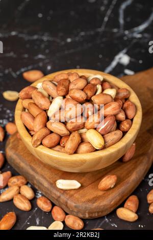 Erdnuss. Erdnüsse, die in einer Holzschüssel geschält wurden. Superfood. Vegetarisches Speisenkonzept. Gesunde Snacks. Schließen Stockfoto