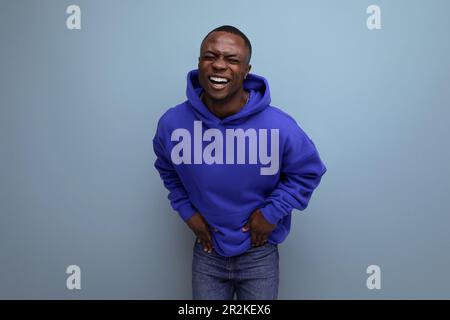 Nahaufnahme eines lachenden schwarzen amerikaners in einem Sweatshirt mit Kapuze auf einem Studiohintergrund mit Kopierbereich Stockfoto