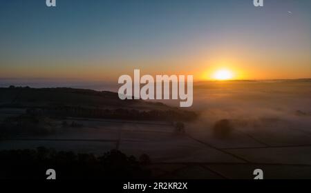 Ein ruhiger Sonnenaufgang malt den Himmel in Orange und Pink, eine perfekte Erinnerung an die Schönheit der Natur. Stockfoto