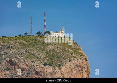 Leuchtturm von Cabo de San Antonio in Jávea im Naturpark Montgo. Kleiner Leuchtturm auf der Klippe. Vom Meer aus an Bord eines Schiffes Stockfoto