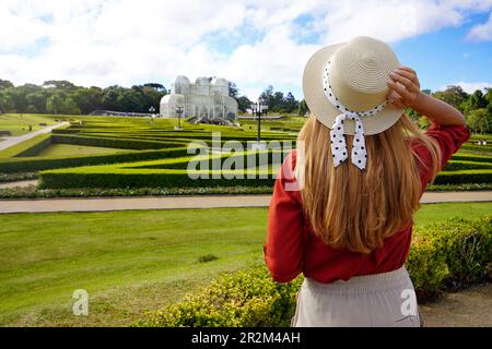 Tourismus in Curitiba, Brasilien. Wunderschönes Mädchen mit Hut, das den Botanischen Garten von Curitiba, Parana, Brasilien besucht Stockfoto