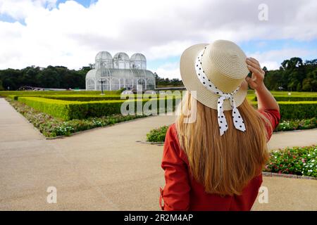 Wunderschöne, stilvolle Frau mit Hut, die den Botanischen Garten von Curitiba, Brasilien, besucht Stockfoto