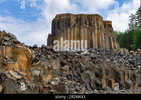 Geologische Basaltfelsformation. Basaltsteinbruch. Säulenbasaltbruch im Sommer. Vulkansteine. Stockfoto