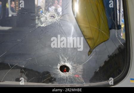 München, Deutschland. 20. Mai 2023. Einschusslöcher sind in der Windschutzscheibe eines zerstörten ukrainischen Krankenwagens während einer Kundgebung auf dem Marienplatz gegen den Krieg in der Ukraine zu sehen. Anschließend wird der Krankenwagen vom 22. Bis 27. Mai auf dem Rindermarkt ausgestellt und dann zu verschiedenen Städten in Europa gefahren. Kredit: Felix Hörhager/dpa/Alamy Live News Stockfoto