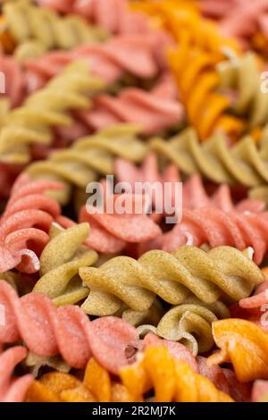 Reisgemüse-Pasta in Spiralform, Draufsicht. Gesunde Reispasta mit Tomaten, Selenera, Karotten und Rüben Stockfoto