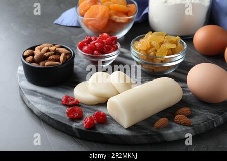 Marzipan und andere Zutaten für hausgemachtes Stollen auf grauem Tisch. Traditionelles deutsches Weihnachtsbrot backen Stockfoto