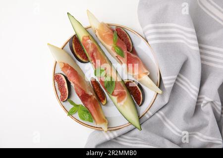 Teller mit leckerer Melone, Jamon und Feigen auf weißem Tisch, Draufsicht Stockfoto