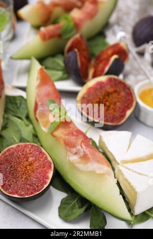 Leckere Melone, Jamon und Feigen, serviert auf weißem Teller, Nahaufnahme Stockfoto