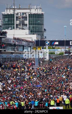 20. Mai 2023, Rheinland-Pfalz, Nürburg: Vor dem Beginn des 24-stündigen Rennens auf dem Nürburgring drängen sich Tausende von Motorsportfans auf das Startfeld. Foto: Thomas Frey/dpa Stockfoto