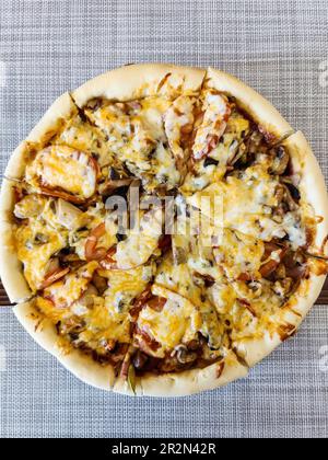 Köstliche gegrillte Pizza mit Auberginen, Zucchini, Tomaten, Oliven, Hühnerfleisch, Pilze und gefüllt mit Käse. Auf eine Serviette gelegt. Draufsicht Stockfoto
