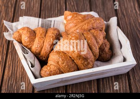 frisch gebackene Croissants auf Holztisch Stockfoto