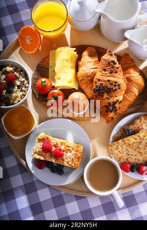 Frühstück serviert mit Kaffee, Orangensaft, Croissants, Pfannkuchen, Ei, Getreide und Obst Stockfoto