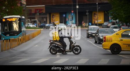 Bukarest, Rumänien - 3. Mai 2023: Ein Glovo-Kurier liefert Lebensmittel in Bukarest, Rumänien. Stockfoto