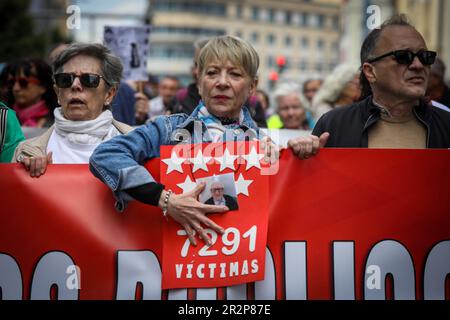 Madrid, Spanien. 20. Mai 2023. Eine Frau besitzt ein Foto ihres Vaters, der während der COVID-19-Pandemie in einem öffentlichen Pflegeheim starb. Das Foto ist auf der Flagge der Gemeinschaft Madrid gedruckt. 1.000 Menschen haben gezeigt, dass sie die öffentlichen Dienstleistungen Spaniens verteidigen. Der marsch wurde von fast zwanzig Gruppen und sozialen Vereinigungen aus den Bereichen Gesundheit, Wohnraum, Pflegeheime, öffentliche Angestellte und Taxifahrer einberufen. Die Demonstration führte durch Madrids Gran Via von der Plaza España nach Cibeles. Kredit: SOPA Images Limited/Alamy Live News Stockfoto