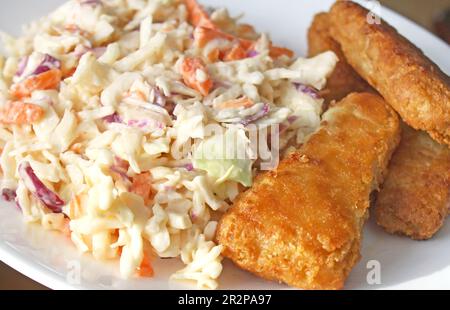 Gebratener Fisch, golden und knusprig mit einer Seite cremigen hausgemachten Krautsalats Stockfoto