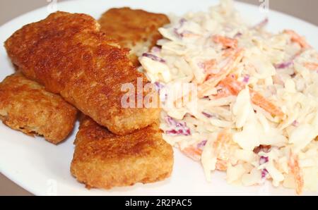 Gebratener Fisch, golden und knusprig mit einer Seite cremigen hausgemachten Krautsalats Stockfoto