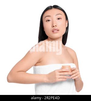 Wunderschöne junge Asiatin mit einem Glas Körpercreme auf weißem Hintergrund Stockfoto