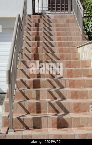 Wunderschöne geflieste Treppen mit Metallgeländern im Freien Stockfoto