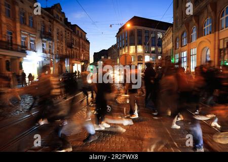 Menschen überqueren nachts die Straße, Langzeitbelichtung Stockfoto