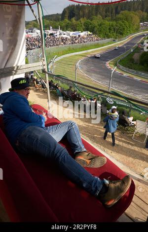 20. Mai 2023, Rheinland-Pfalz, Nürburg: Motorsportfan Tobias liegt während des 24-stündigen Rennens auf dem Nürburgring im Abschnitt „Brünnchen“ auf seiner Couch, die er auf einem hohen Sitz montiert hat. Foto: Thomas Frey/dpa Credit: dpa Picture Alliance/Alamy Live News Stockfoto