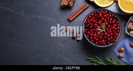 Flache Laienzusammensetzung mit frischen reifen Cranbeeren auf dunkelgrauem Tisch, Platz für Text. Bannerdesign Stockfoto