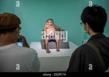 Taipeh. 21. Mai 2023. Die Menschen betrachten Graham eine Skulptur des deformierten Menschen von Patricia Piccinini während des ÜBERNATÜRLICHEN: Skulpturenvisionen der Körperausstellung in Taipei, Taiwan am 05./21/2023. Die Skulpturen, die in der Ausstellung ausgestellt werden, erforschen die Zukunft des menschlichen Körpers in der Anthropozenen Ära. Von Wiktor Dabkowski Credit: dpa/Alamy Live News Stockfoto