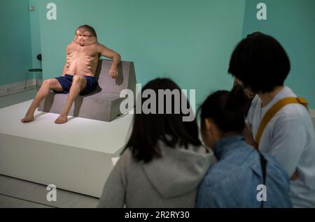 Taipeh. 21. Mai 2023. Die Menschen betrachten Graham eine Skulptur des deformierten Menschen von Patricia Piccinini während des ÜBERNATÜRLICHEN: Skulpturenvisionen der Körperausstellung in Taipei, Taiwan am 05./21/2023. Die Skulpturen, die in der Ausstellung ausgestellt werden, erforschen die Zukunft des menschlichen Körpers in der Anthropozenen Ära. Von Wiktor Dabkowski Credit: dpa/Alamy Live News Stockfoto