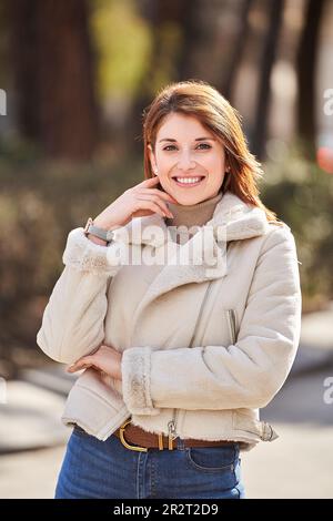 Porträt einer rothaarigen Frau, die lächelt und vor der Kamera im Park posiert Stockfoto