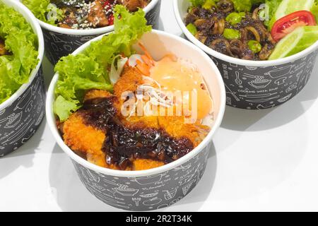 Gebratenes Hähnchen in scharfer Sauce mit Sesam und Chicken Katsu mit Gemüse isoliert auf weißem Hintergrund. Fast-Food-Konzept Stockfoto