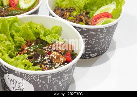 Gebratenes Hähnchen in scharfer Sauce mit Sesam und Chicken Katsu mit Gemüse isoliert auf weißem Hintergrund. Fast-Food-Konzept Stockfoto