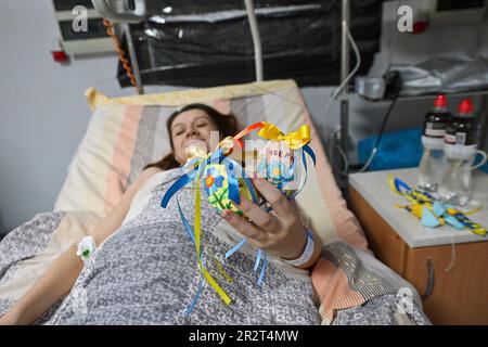 Nicht exklusiv: ZAPORIZHZHIA, UKRAINE - 18. MAI 2023 - Eine neue Mutter demonstriert ein Pysanka-Amulett im Zaporizhzhia Perinatal Center, Zaporizhzhia, s. Stockfoto