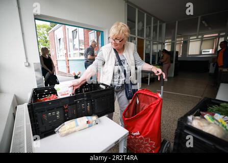 PRODUKTION – 15. Mai 2023, Schleswig-Holstein, Lübeck: Eine Kundin packt ihre Speisen am Teilereihafen Junge Tafel am Kolberger Platz. An der Junge Tafel in Lübeck verteilen Studenten und Jugendliche Nahrungsmittel an Bedürftige. (Zu dpa 'die Macher des Jungen Tafel Lübeck wollen junge Menschen dazu inspirieren, sich freiwillig zu engagieren') Foto: Christian Charisius/dpa Stockfoto