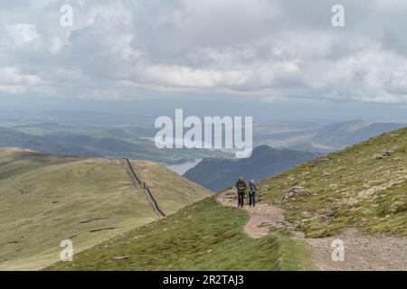 Wanderer auf dem Weg zum Flussufer, Helvellyn, mit ullswater See hinter dem cumbria english Lake District Stockfoto