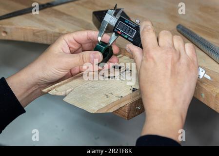 Juwelierin, die den Wachsring misst, bevor der Metallring geformt und gegossen wird. Stockfoto