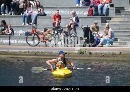 Brindleyplace, Birmingham, 21. Mai 2023 - Besucher des Stadtzentrums von Birmingham genossen Temperaturen von bis zu 21 Grad Celsius, während sich das Wetter zu sommerlicheren Bedingungen zu wenden beginnt. Die Leute genossen Bootstouren auf den Kanälen und benutzten Liegestühle, um sich in Brindleyplace zu sonnen. Kajakfahrer wurden auch auf den Kanälen gesehen, während andere vom Kanal aus zuschauten. Kredit: Stop Press Media / Alamy Live News Stockfoto