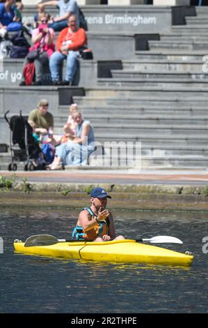 Brindleyplace, Birmingham, 21. Mai 2023 - Besucher des Stadtzentrums von Birmingham genossen Temperaturen von bis zu 21 Grad Celsius, während sich das Wetter zu sommerlicheren Bedingungen zu wenden beginnt. Die Leute genossen Bootstouren auf den Kanälen und benutzten Liegestühle, um sich in Brindleyplace zu sonnen. Kajakfahrer wurden auch auf den Kanälen gesehen, während andere vom Kanal aus zuschauten. Kredit: Stop Press Media / Alamy Live News Stockfoto