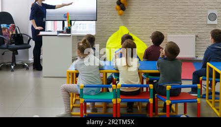 Der Lehrer führt eine Lektion für eine Gruppe von Vorschulkindern in einem Kinderpädagogischen Zentrum durch. Stockfoto