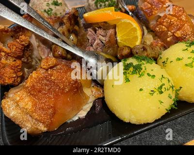 bayerisches Schweinebraten. Gemischter Braten mit Teigtaschen Stockfoto