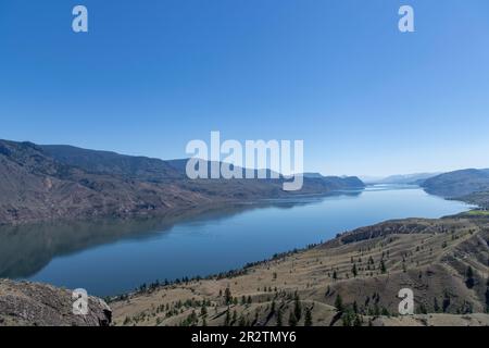 Panoramablick über Kamloops Lake und umliegende Berge am Thompson River, westlich von Kamloops, BC, Kanada, vor klarem blauen Himmel und Ruhe Stockfoto